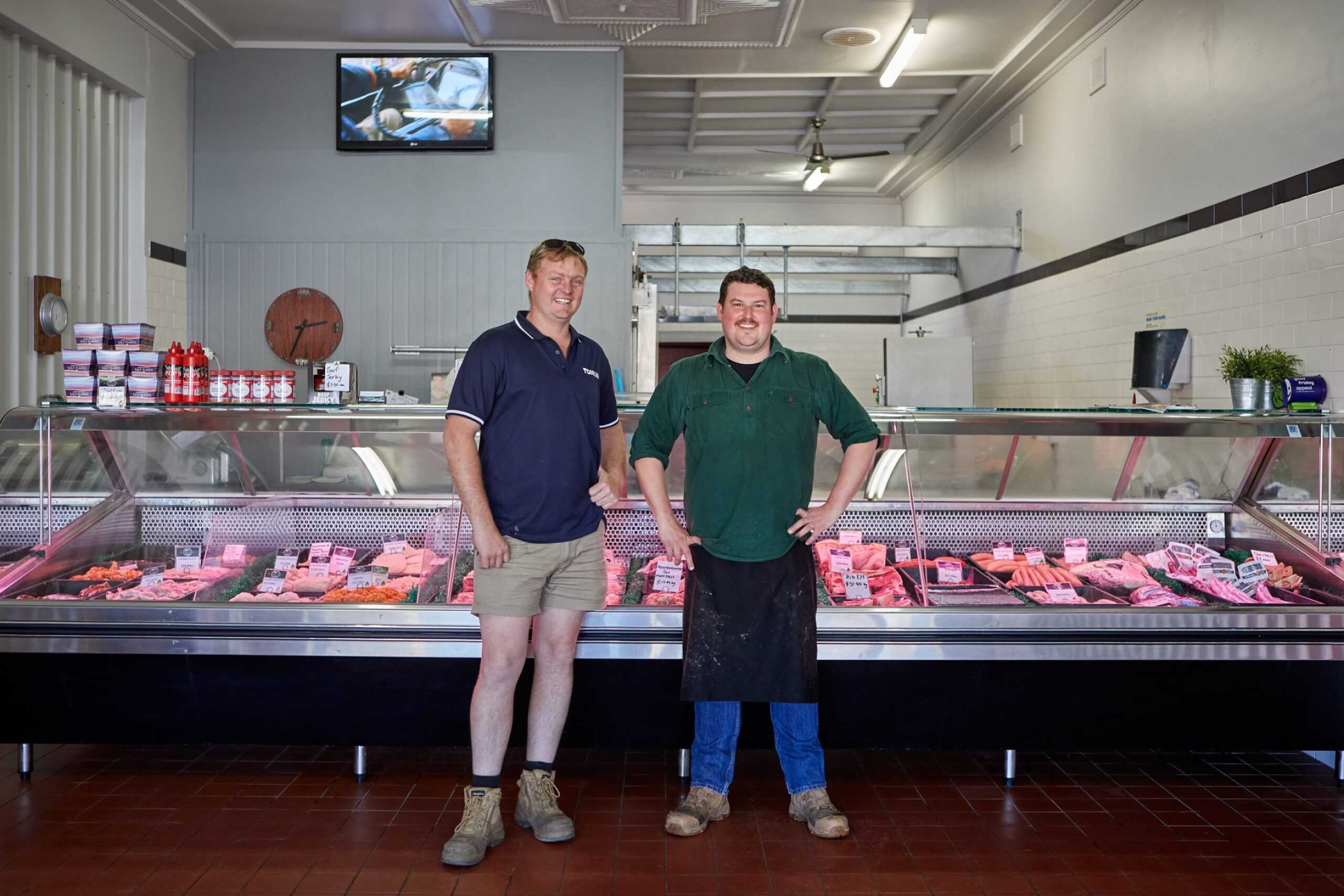 A Tonkin group employee stood with a local butcher in front of a meat counter.