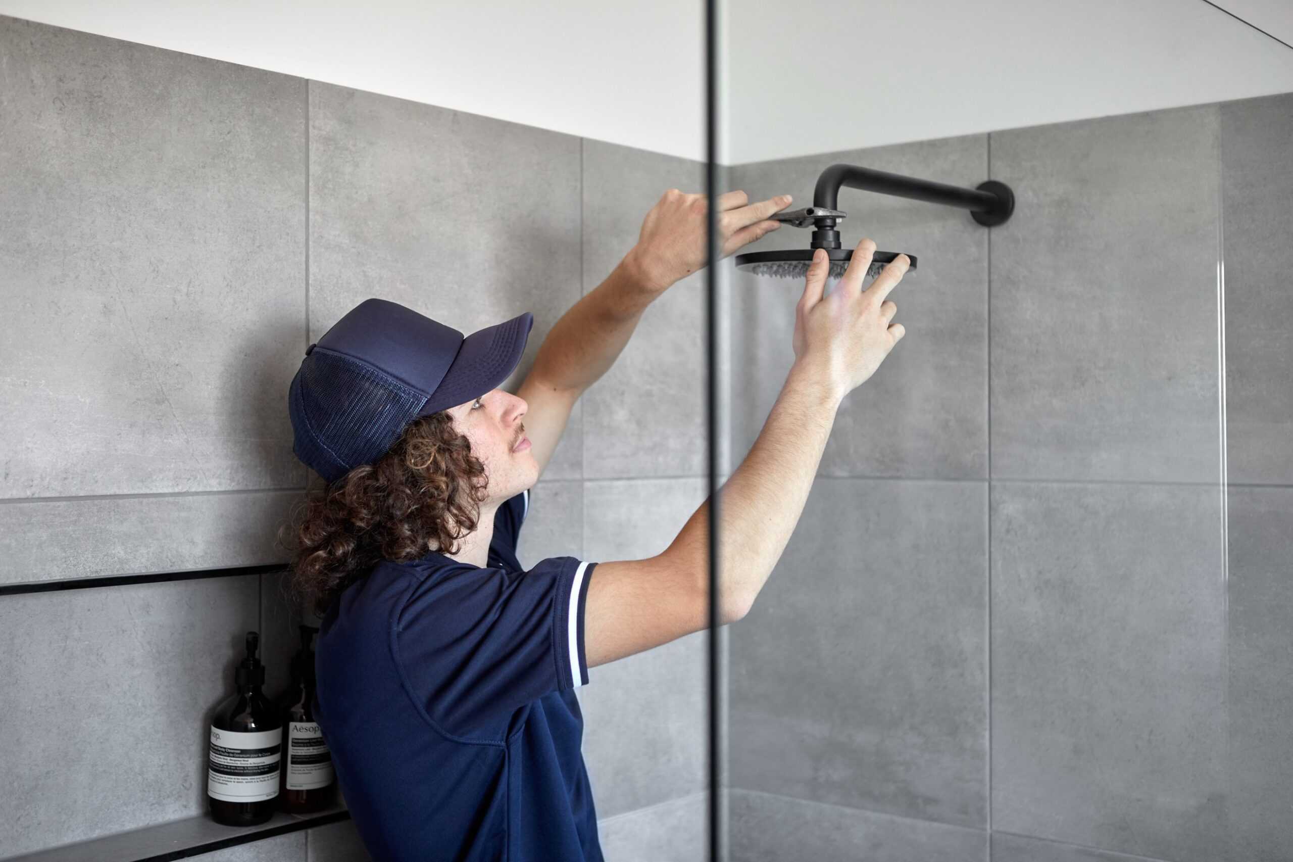 A Tonkin Group employee changing a shower head.